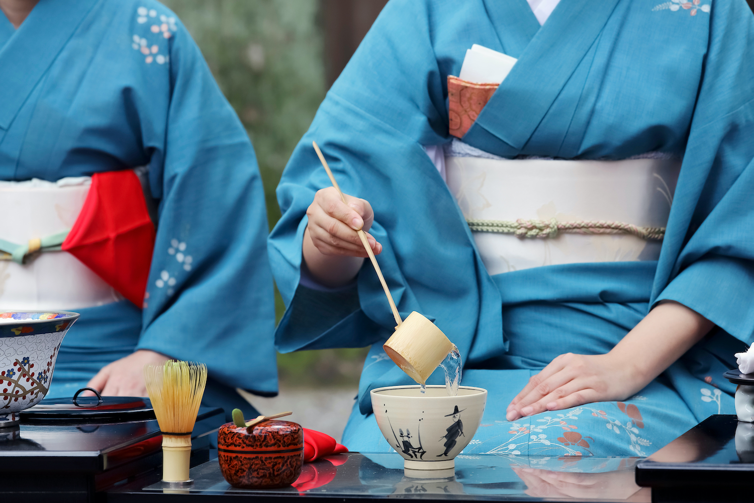 Japanese woman in traditional kimono preparing Japanese green tea ceremony at garden