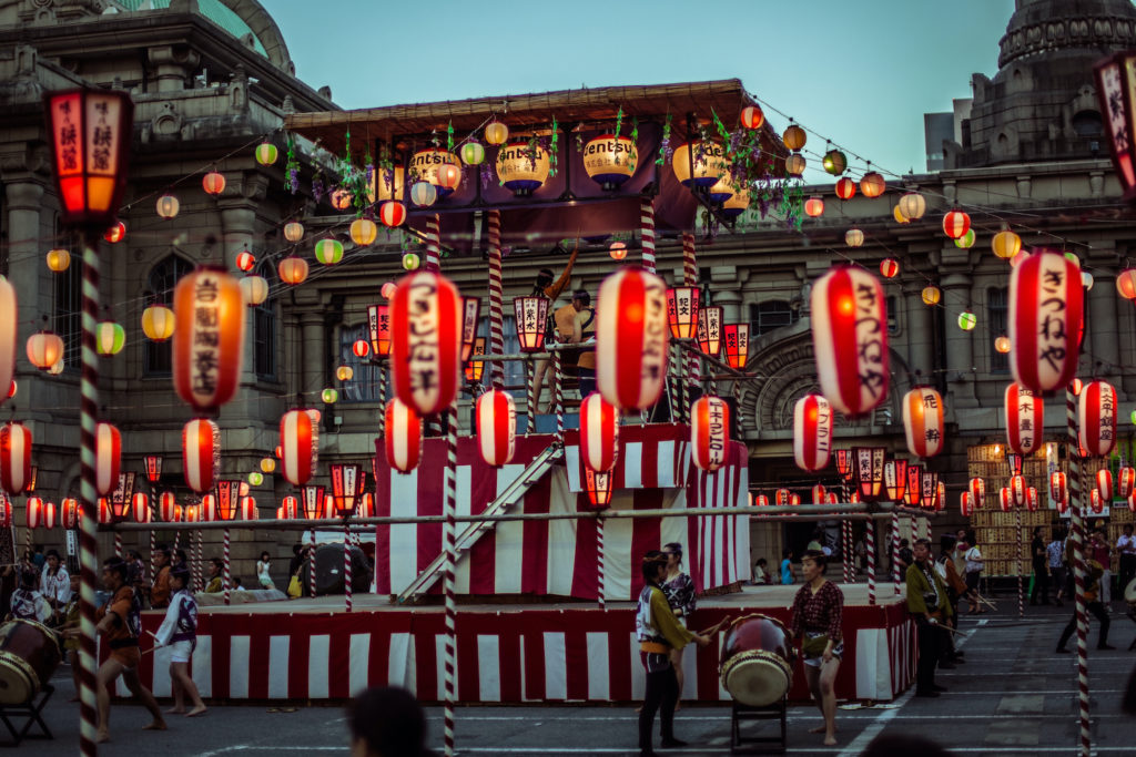 TOKYO, JAPAN - AUGUST 10 2012: Paper lanterns and the stage of the Tsukiji Honganji Bon Odori Matsuri - the popular festival in Tokyo. Text on the lanterns are names of the festival sponsors.