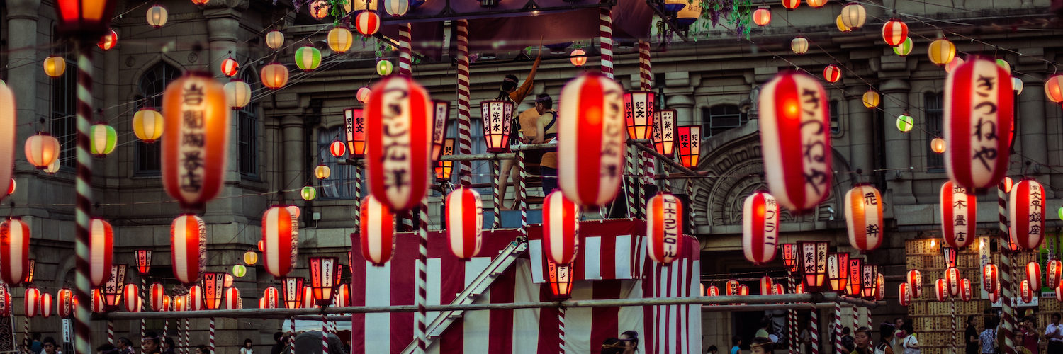 TOKYO, JAPAN - AUGUST 10 2012: Paper lanterns and the stage of the Tsukiji Honganji Bon Odori Matsuri - the popular festival in Tokyo. Text on the lanterns are names of the festival sponsors.