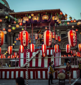 TOKYO, JAPAN - AUGUST 10 2012: Paper lanterns and the stage of the Tsukiji Honganji Bon Odori Matsuri - the popular festival in Tokyo. Text on the lanterns are names of the festival sponsors.