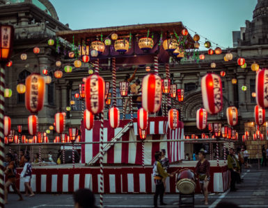 TOKYO, JAPAN - AUGUST 10 2012: Paper lanterns and the stage of the Tsukiji Honganji Bon Odori Matsuri - the popular festival in Tokyo. Text on the lanterns are names of the festival sponsors.