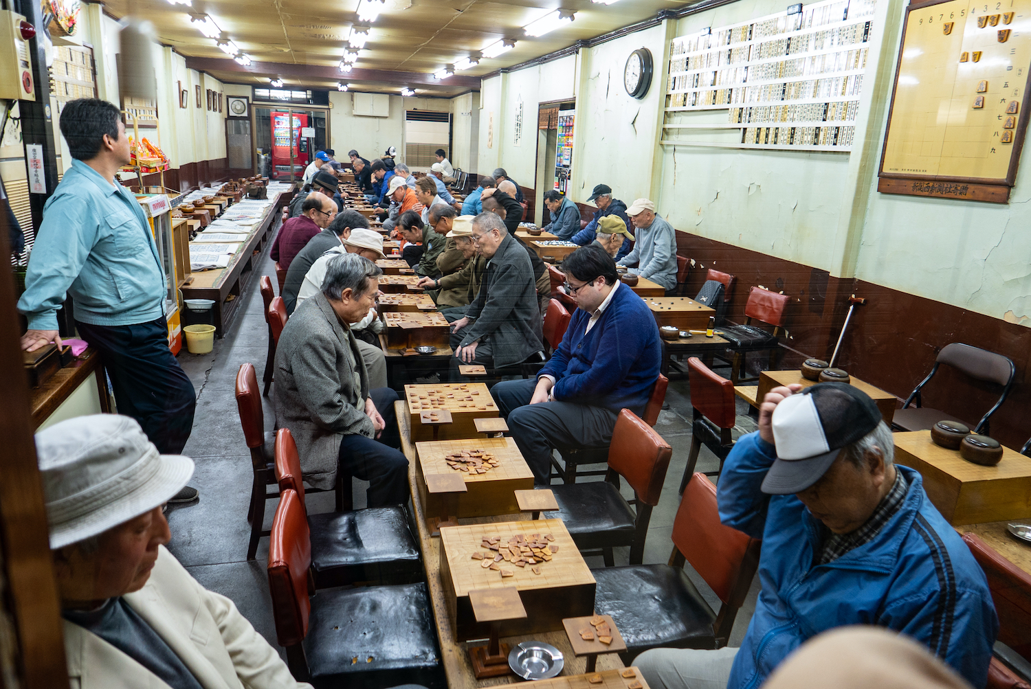 Interior shot of Japanese people playing Shogi or Japanese chess at  Kuromon Ichiba Market in Osaka, Japan.