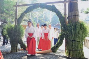 Shinto ritual, Nagoshi-no-Harae, Summer purification , Shinto female shaman, Miko ig going through the huge ring to purify the impurity