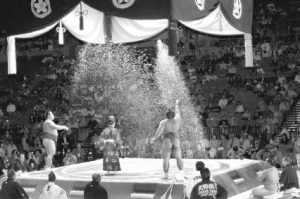 Sumo wrestlers scattering salt to purify the ring before a bout