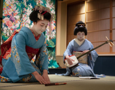 Kyoto, Japan - May 19, 2019: Maiko bows at the end of traditional performance in a small Japanese inn with geisha behind