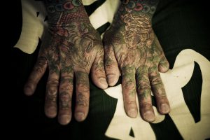 Tattooed hands with a digit missing. by Anton Kusters