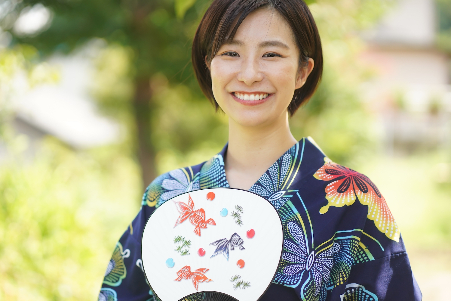 A short-haired woman in Yukata holding a fan