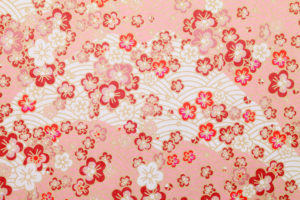 Traditional Japanese pattern paper, flowers in red to pink tone with white waves behind